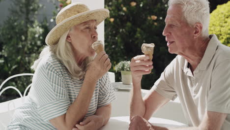 elderly couple enjoying ice cream on a patio