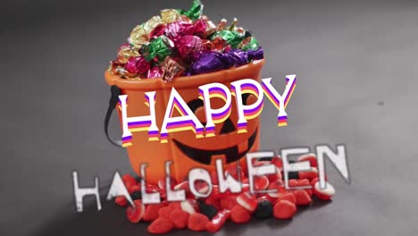 Animation-of-halloween-text-over-carved-pumpkin-bucket-with-sweets-on-grey-background