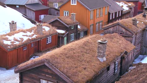 thatch roofed wooden buildings line the streets of the old historic mining town of roros in norway