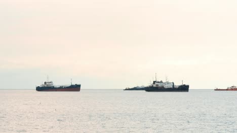 Naval-maritime-ships-anchored-in-shallow-oceanic-territorial-waters-at-the-coast-of-Panama-Citys's-Causeway-of-Amador-during-a-cloudy-summer-day