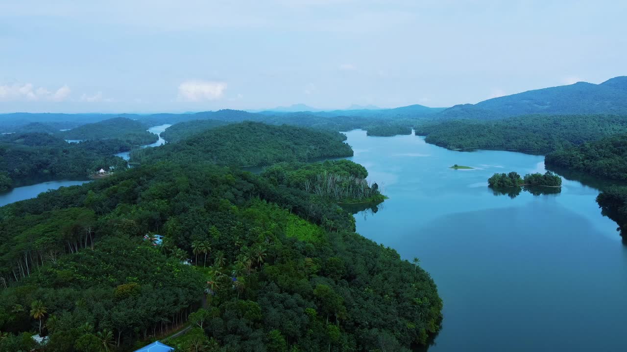 High angle view of a very beautiful tourist place, Morning view of Neyyar dam, Mountains and small green islands are seen in this video. Beautiful reservoir dam in Kerala, India,