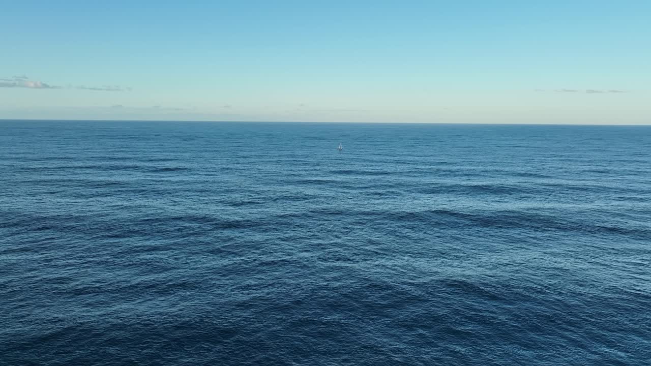 amplia toma aérea de un solo yate de vela solitario en el océano, a toda vela