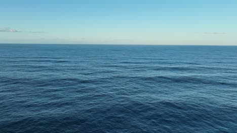 Aerial-wide-shot-of-single-lone-Sailing-Yacht-in-ocean,-at-full-sail