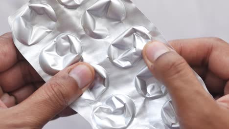 close-up of hands holding an empty blister pack of pills