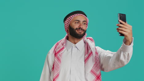 muslim guy takes pictures with phone