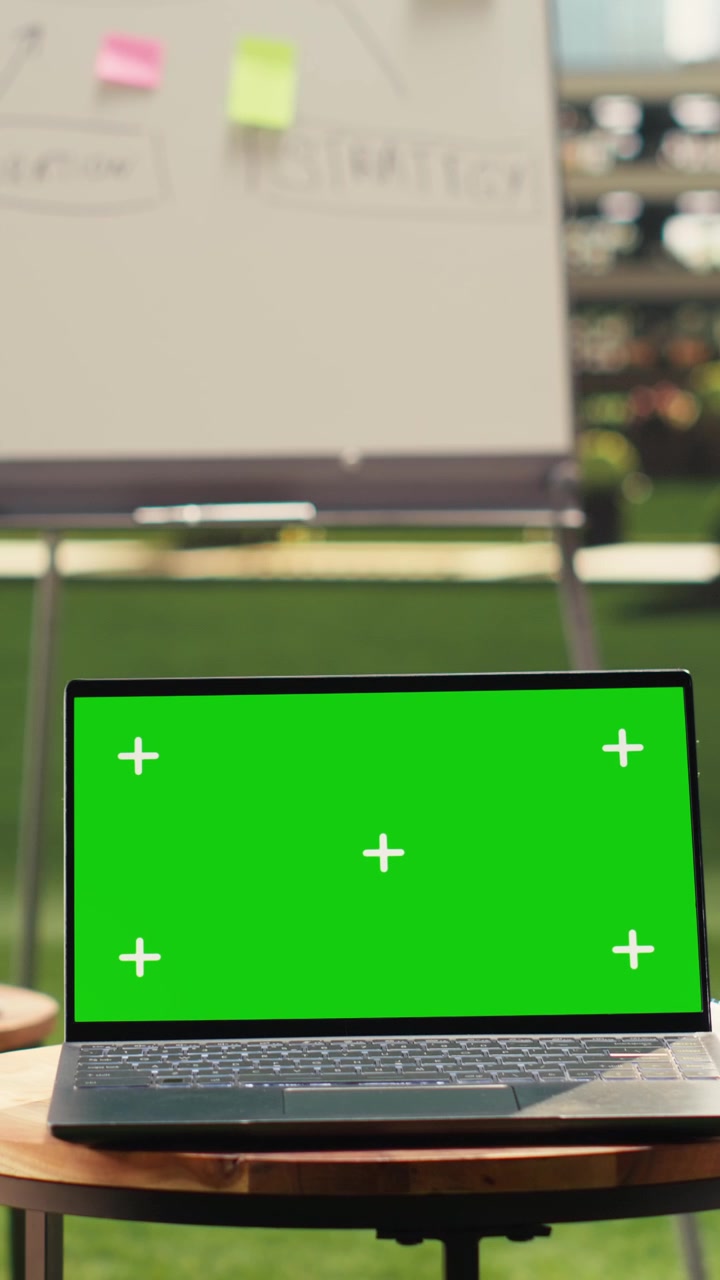 Vertical Video Laptop green screen on table in clean empty rooftop office terrace