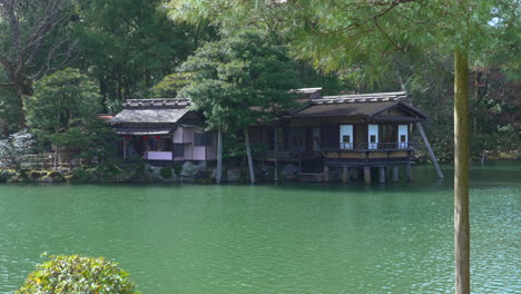 scenic view of traditional tea house by the lakeshore at kenroku-en garden in kanazawa, ishikawa, japan