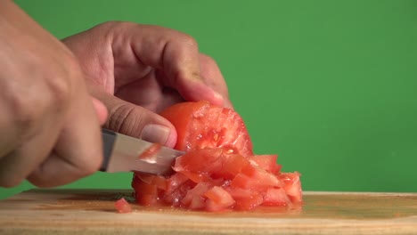 hands dicing a tomato on a chroma background