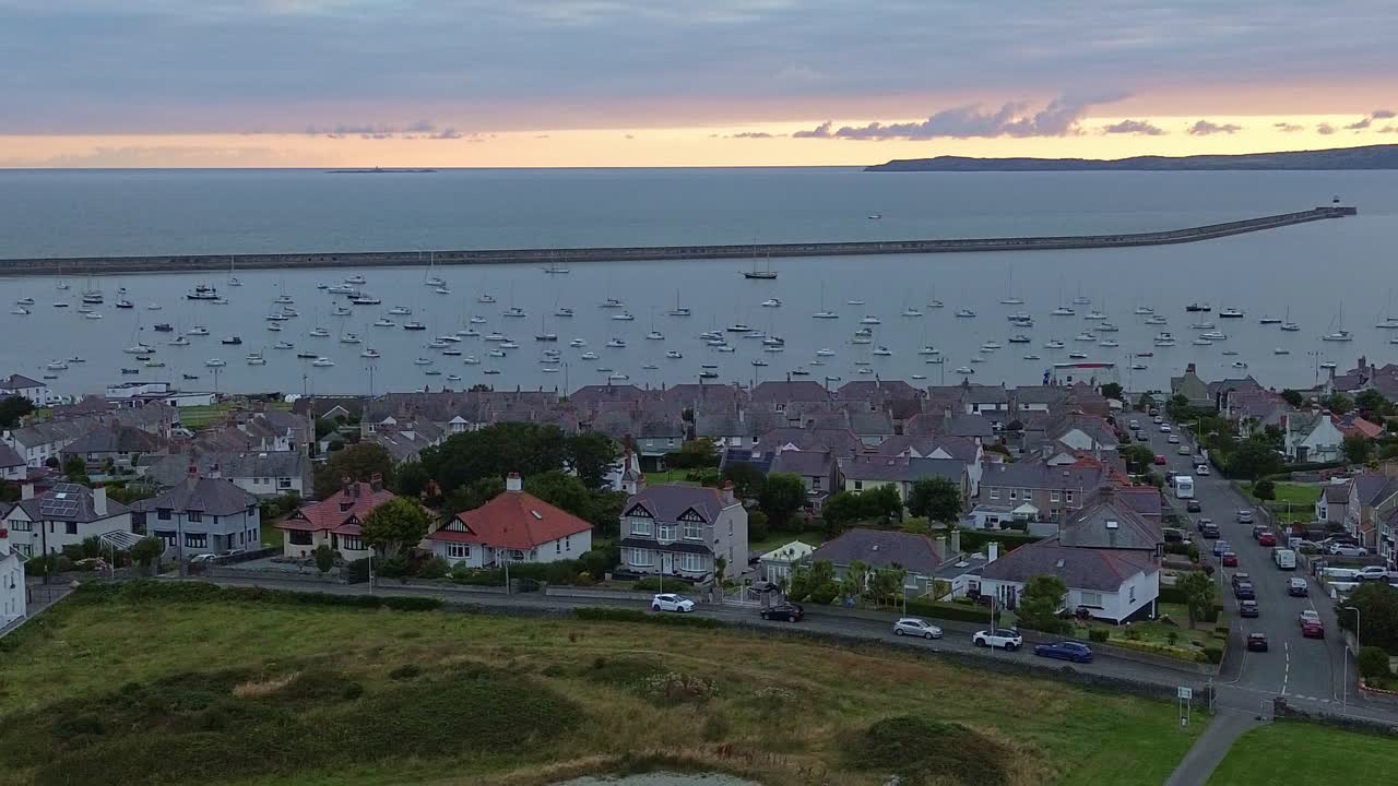 Aerial view across picturesque Holyhead town harbour and breakwater with sunrise mountain horizon