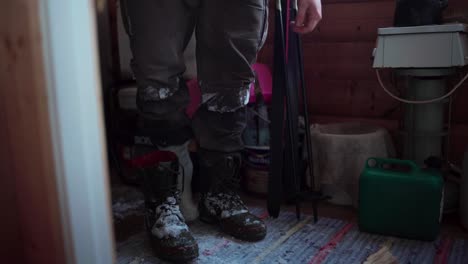 a man is removing his shoes, dusted with snow, during the winter season in bessaker, trondelag county, norway - close up