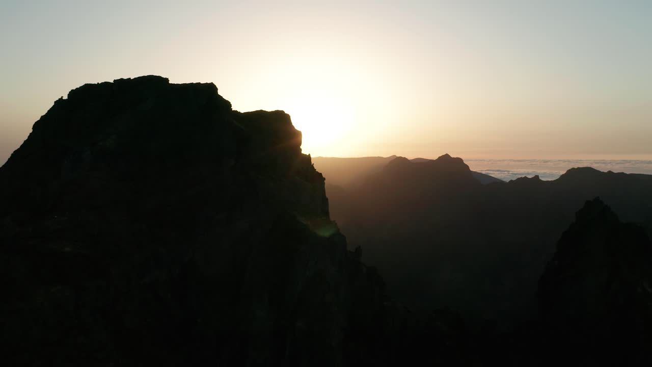 Sagoma scura di montagne aspre a Madeira con un tramonto dorato