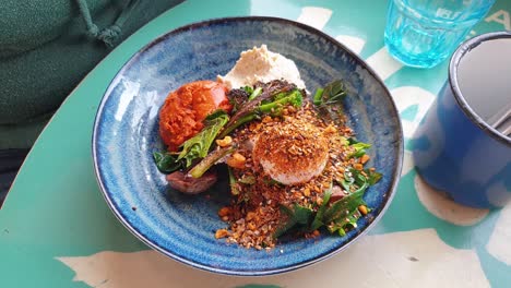 Cerca-De-Una-Mujer-Comiendo-Un-Delicioso-Y-Saludable-Desayuno-Brunch-Bowl-De-Huevos-Escalfados-Con-Verduras-En-El-Café-Local