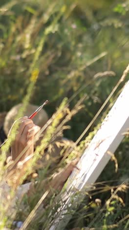 an artist paints a picture on a sunny summer day in a meadow - an artist paints a picture on a sunny summer day in a meadow. artist girl draws nature