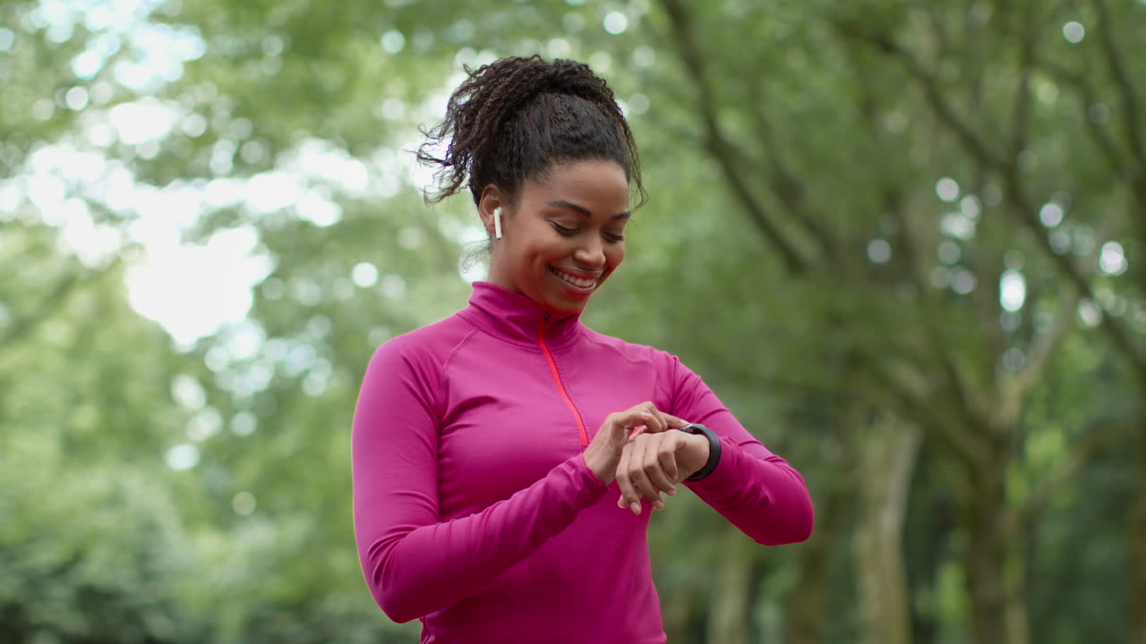 Woman Checking Smartwatch While Running in Park