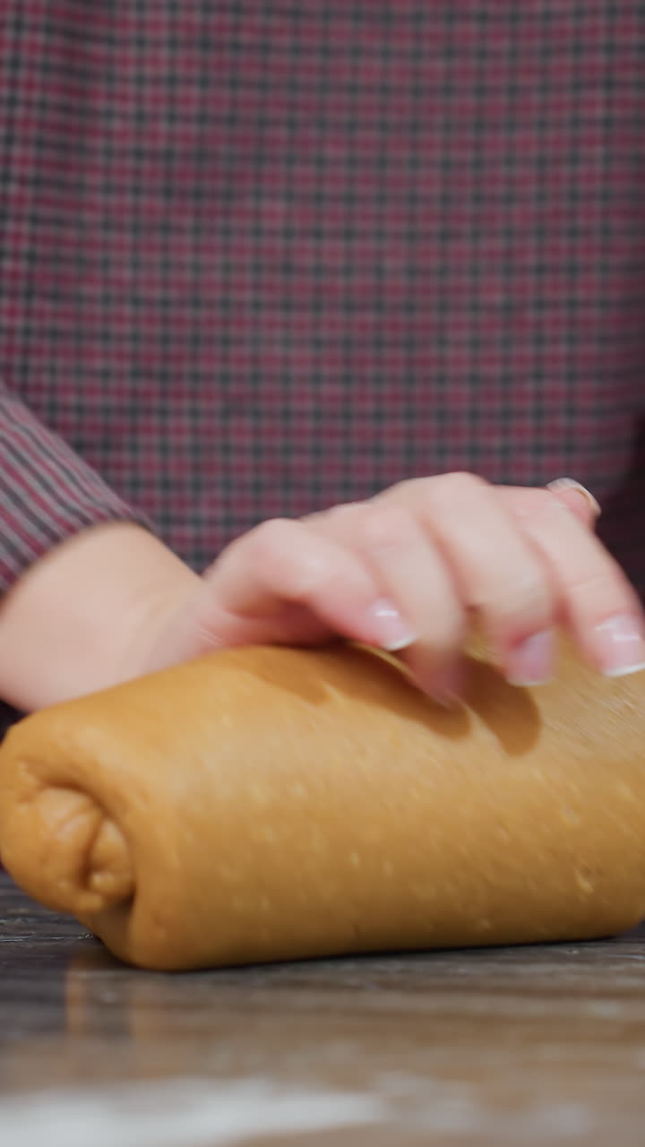 vista parcial del panadero con una pulsera en la mano izquierda amassando masa fresca en el mostrador de la cocina, entorno de cocina moderno, preparando pan casero, rodillo, gabinetes blancos