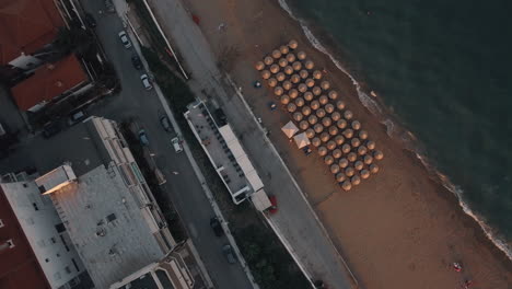 Luftaufnahme-Der-Strandpromenade-Der-Stadt-Mit-Leerem-Strand-Und-Autos,-Die-Auf-Der-Straße-Griechenlands-Fahren