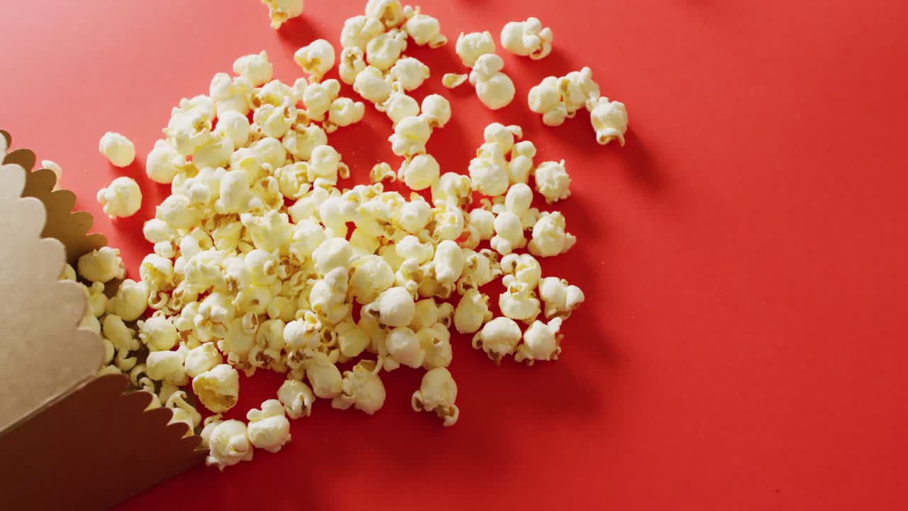 Video of close up of popcorn on red background