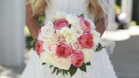 primer plano de la novia sosteniendo un gran ramo de bodas colorido hecho de rosas