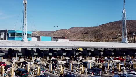 aerial over the san ysidro tijuana us mexico border crossing with cars lined up for miles and border patrol helicopters landing distance