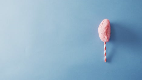 video of marshmallow on stick lying on blue surface