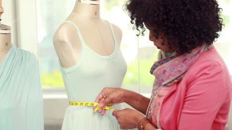 fashion designer measuring dummy waist