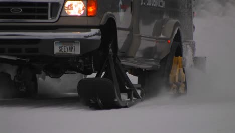 A-snowplow-truck-moves-along-a-snowy-road