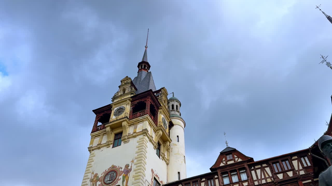 Sinaia, Romania, 17 luglio 2025: torre dell'orologio del Castello di Peleș in Romania. Primo piano della torre dell'orologio del Castello di Peleș a Sinaia, Romania, sotto un cielo nuvoloso e drammatico