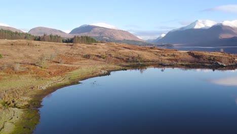 Drohnenaufnahmen-Aus-Der-Luft,-Die-Direkt-Nach-Oben-Fliegen,-Um-Glen-Etive-Und-Die-Ufer-Von-Loch-Etive-Im-Hochland-Von-Schottland-Im-Winter-Mit-Schneebedeckten-Bergen,-Bäumen,-Einem-Wald-Und-Immer-Noch-Reflektierendem-Wasser-Zu-Zeigen