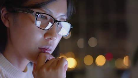 Focused-asian-casual-businesswoman-in-glasses-using-laptop-in-office-at-night,-slow-motion