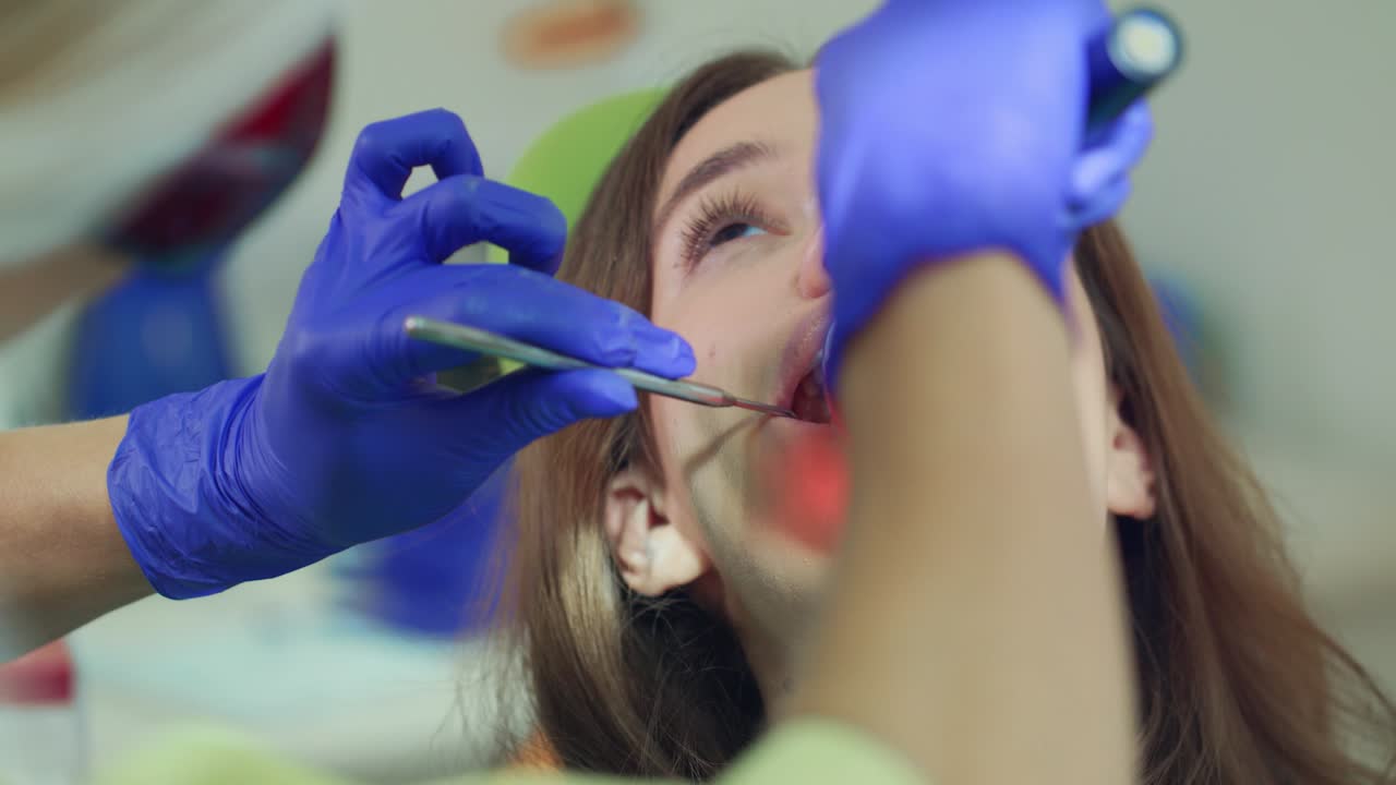 Paciente mulher em procedimento odontológico. Dentista trabalhando com lâmpada de polimerização dental.