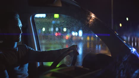 the handsome man sitting behind the steering wheel of a car