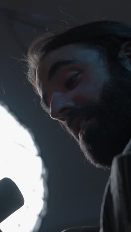 close-up portraits of a man with a beard in dramatic low light