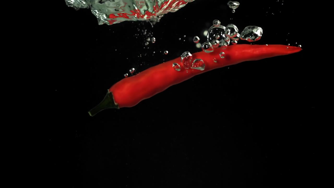 Red Chili Pepper Falling into Water in Slow Motion