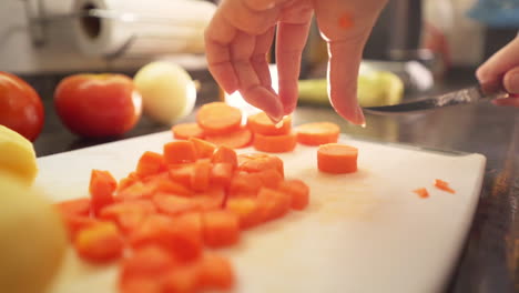 Manos-Femeninas-Cortando-Rodajas-De-Zanahorias-En-La-Cocina-A-Cámara-Lenta