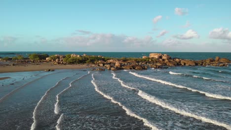 Vista-Aérea-Sobre-Las-Olas-Y-Aguas-Poco-Profundas-En-Una-Playa,-En-Bowen,-Australia---Tire-Hacia-Atrás,-Disparo-De-Drones