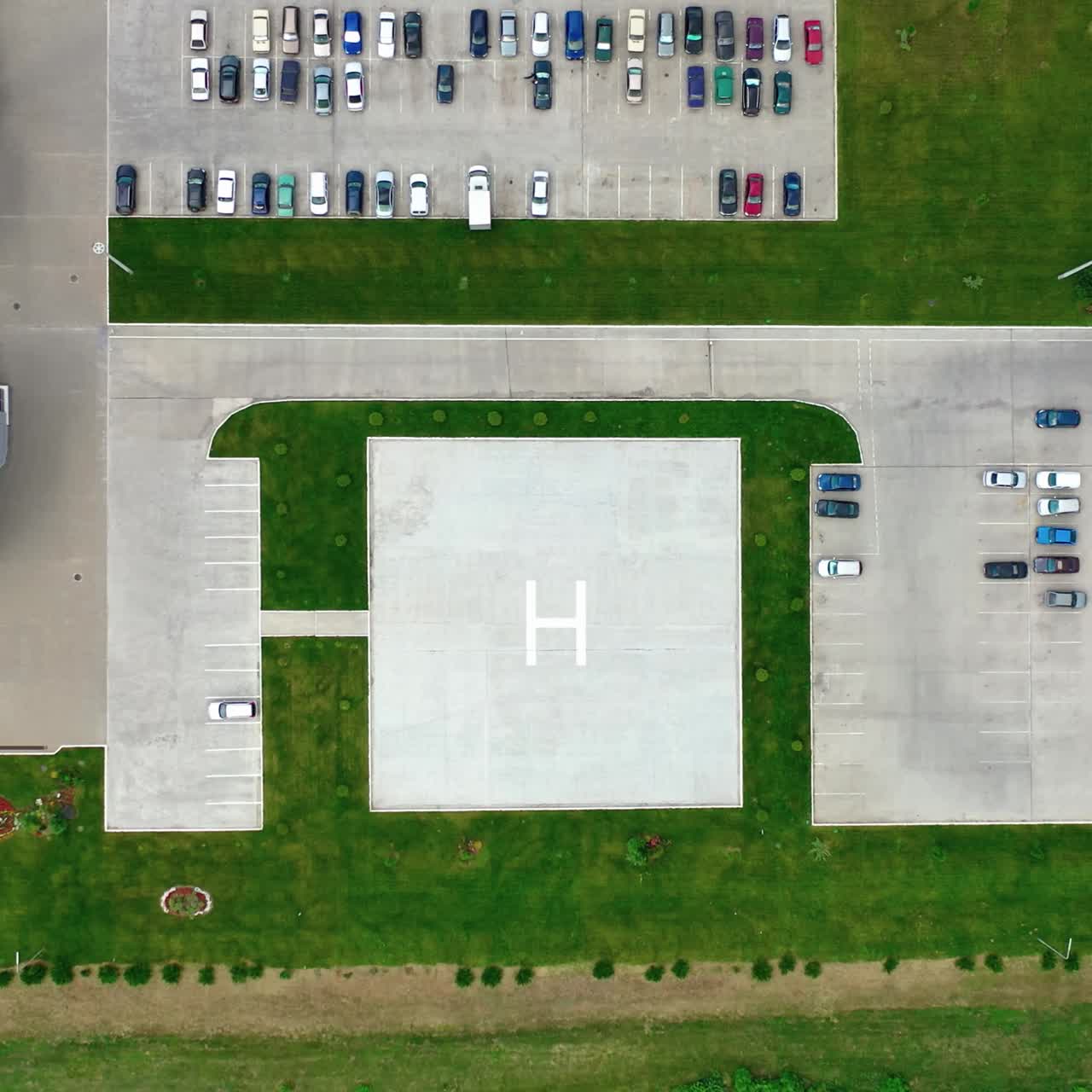 Car parking on a modern plant. Factory on green field with many cars on parking spaces. Camera rising up
