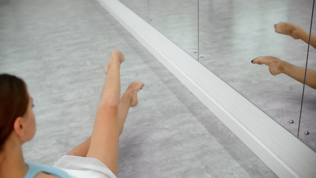 Ballet dancer stretching in studio