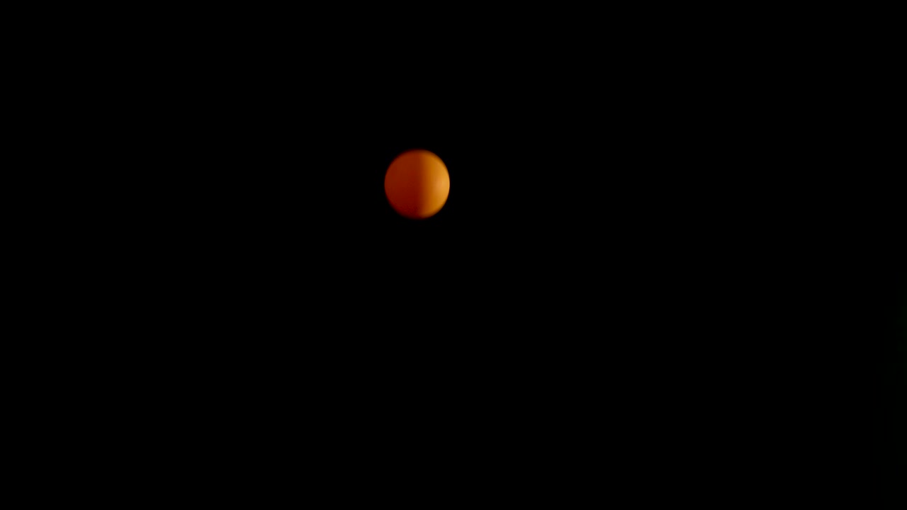 Orange ball bouncing in dark background
