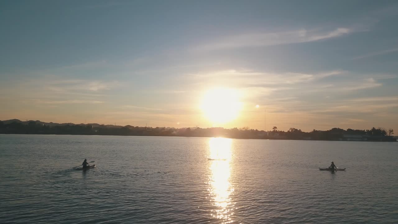 Aerial drone sunset shot of friends doing paddle board and kayaking at the lake