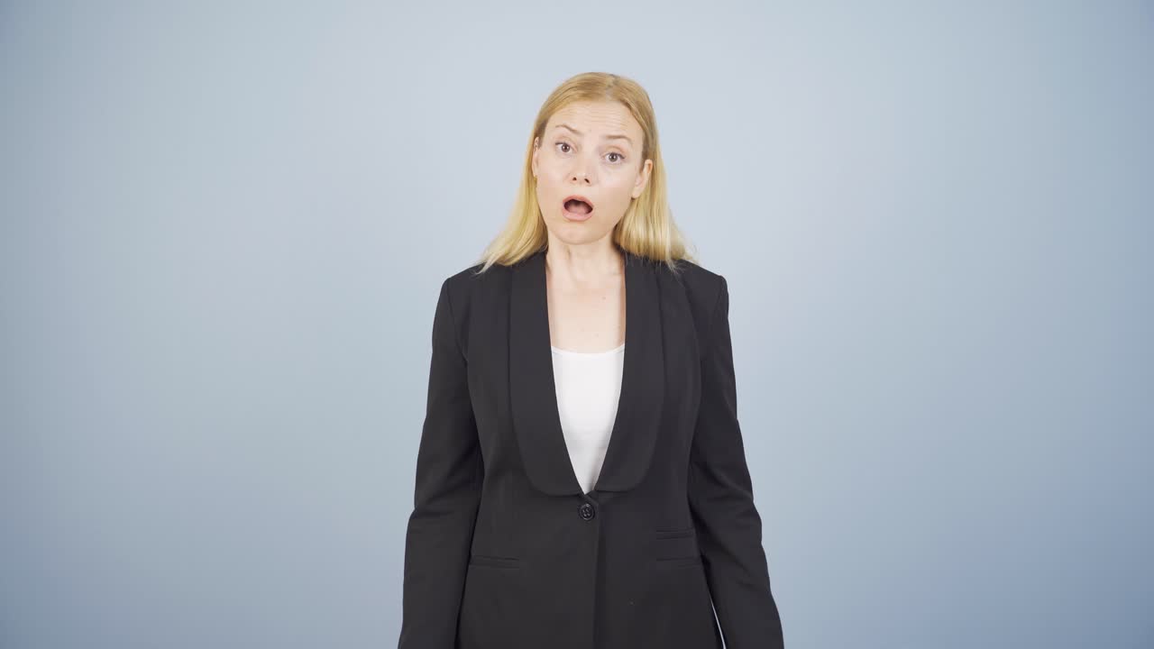 사업가 여성이 놀라서 카메라를 쳐다보고 있습니다.