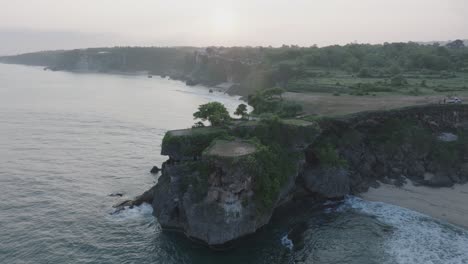 un dron aéreo volando sobre la península tropical de balangan beach al amanecer en uluwatu bali, indonesia