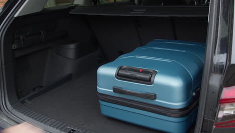 man get all the travel bags in the trunk of his car