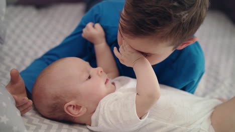 innocent child love. close up of older brother playing with baby boy