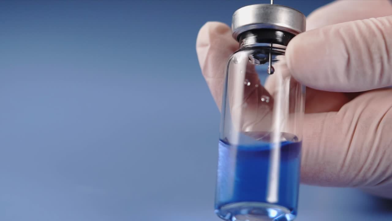 Hand holding a vaccine vial