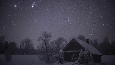 starry night sky over wintry landscape with lone wooden cabin in snow