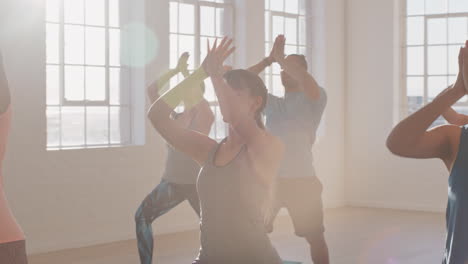 yoga class of young healthy people practicing prayer pose enjoying fitness lifestyle exercising in studio at sunrise