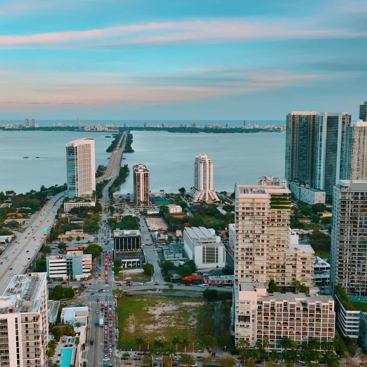 Flight above the diverse architecture in Miami, Florida, USA. Approaching the waterscape of the Atlantic Ocean from aerial perspective.