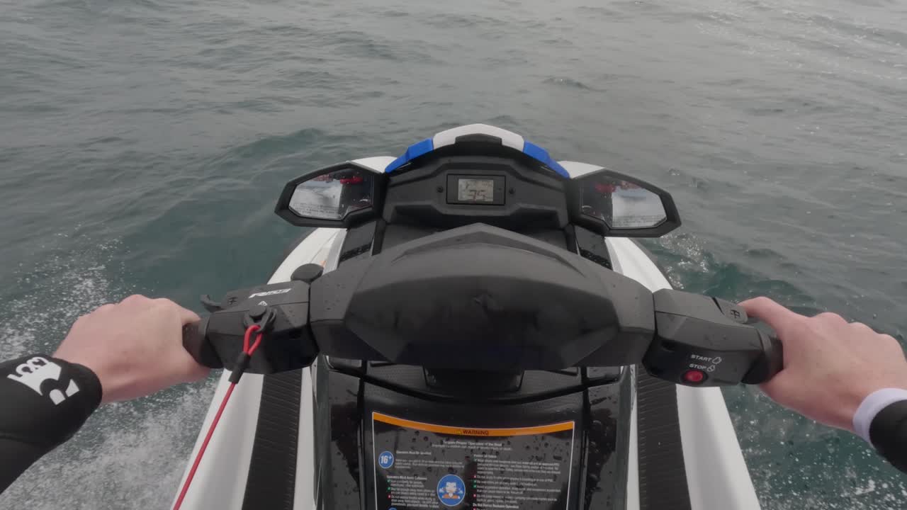 Ripresa POV di un pilota di moto d'acqua che sfreccia sull'oceano, schizzando e cavalcando le onde
