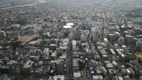 aerial scenic urban drone footage of a neighborhood, streets and buildings in the capital city of tokyo, japan during sunset