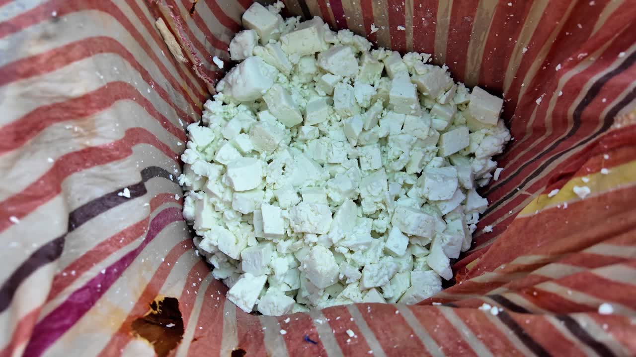 An intimate view of fresh artisanal cheese curds wrapped in a cloth, capturing the authentic texture of a traditional, handmade recipe